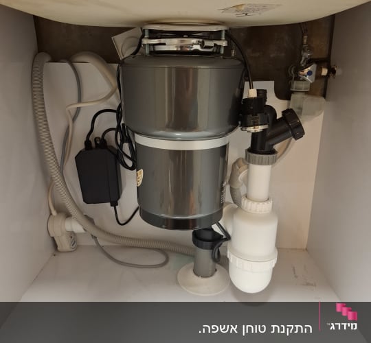מתקן טוחן אשפה מתחת לכיור עם צינורות וחיבורים